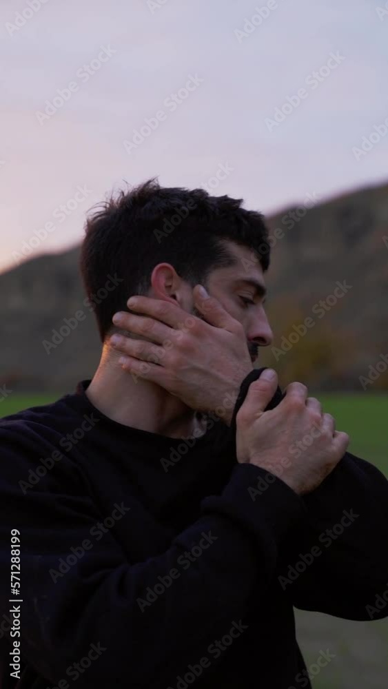 vertical shot close up in slow motion arab man performance dancing emotive contemporary dance with hands up in field with sunset light vertical shot close up in slow motion arab man performance dancing emotive contemporary dance with hands up in field with sunset light