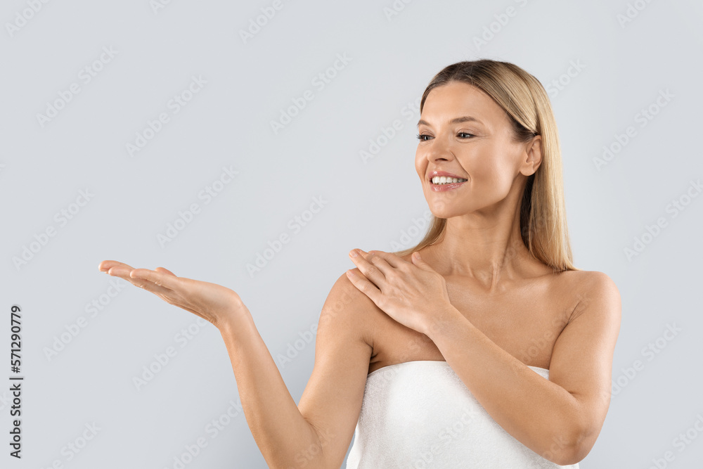 Cheerful attractive blonde woman showing something on her hand Cheerful attractive blonde woman showing something on her hand