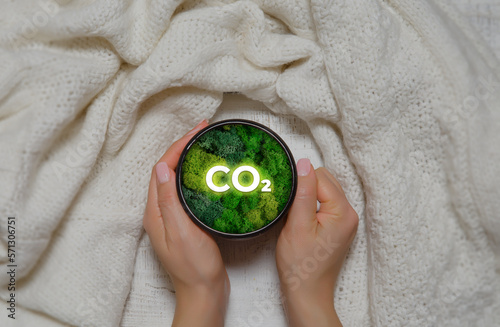 Hand of human holding mug with green plant and text as a symbol of protection of nature. Ecology and world sustainable environment concept. Conceptual image. Earth day.