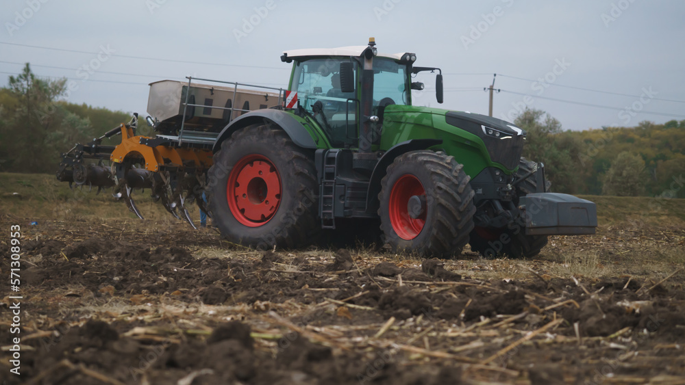 Tractor working in the field. Autumn tillage. Deep ripping with powerful tractor Tractor working in the field. Autumn tillage. Deep ripping with powerful tractor
