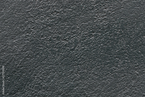 Abstract dark gray painted stone uneven texture, black wall background.