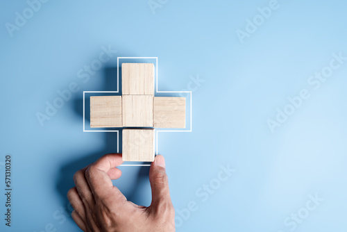 Health insurance concept. people hands putting plus symbol and healthcare medical wooden cube block with icon, health and access to welfare health concept...