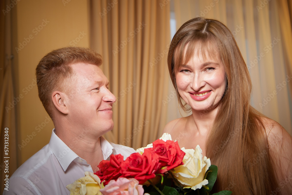 An adult couple of newlyweds in beautiful dress in a hotel room after the wedding. A guy and a girl, a man and a woman in a beautiful room. The concept of love and care
