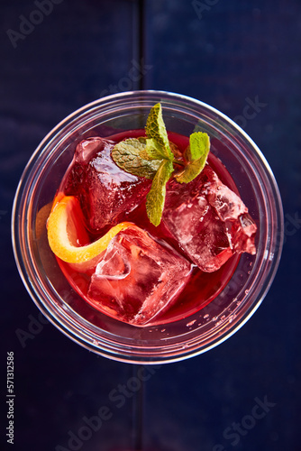 red summer cocktail with lemon and mint top view on blue brane stand, measuring cup, strainer, jiger photo