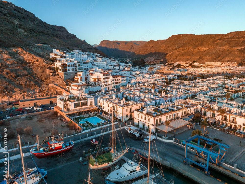 Puerto de Mogan fishing town aerial view at sunset. Traditional colorful buildings with many fishing boats at Gran Canaria, Canary Islands, Spain