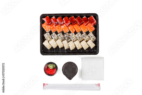 A set of sushi in a delivery box  soy sauce  chopsticks  wasabi  ginger on a white background