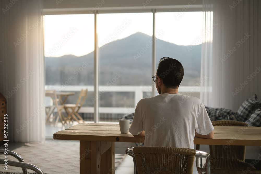 a man is resting in a country house in the mountains and drinking tea sitting on an armchair a man is resting in a country house in the mountains and drinking tea sitting on an armchair