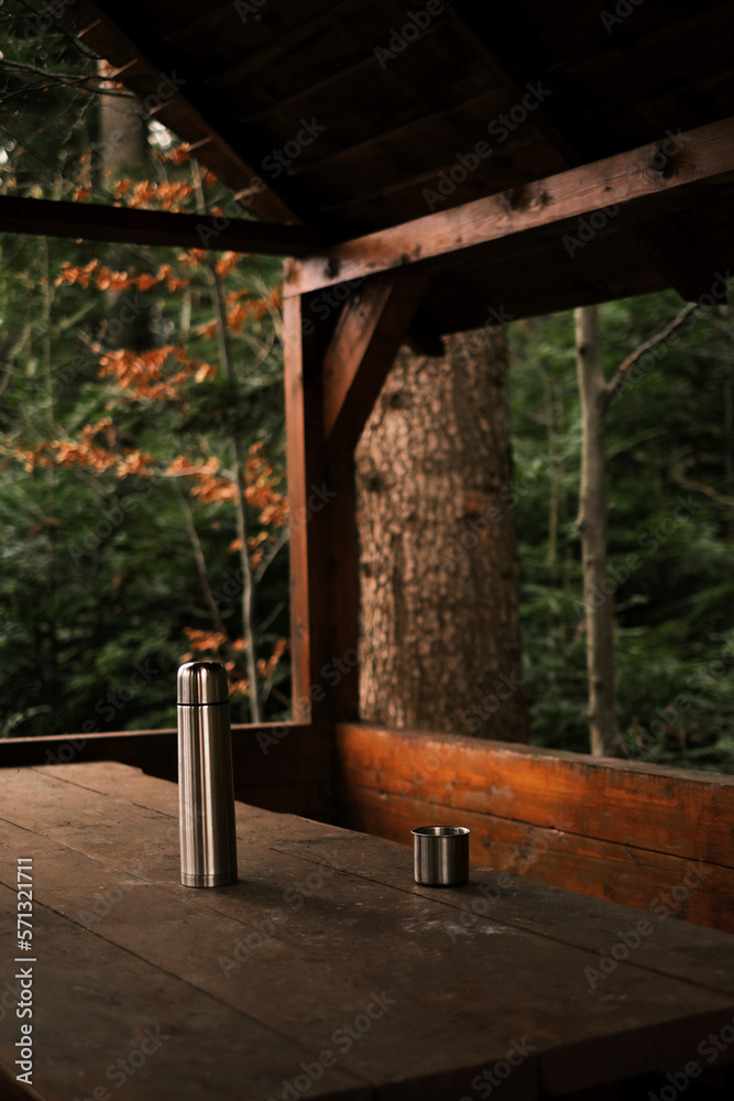 thermos with a metal bowl in the gazebo for relaxing in the mountains