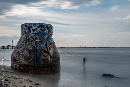 concrete constructon on the beach with cloudy sky on background