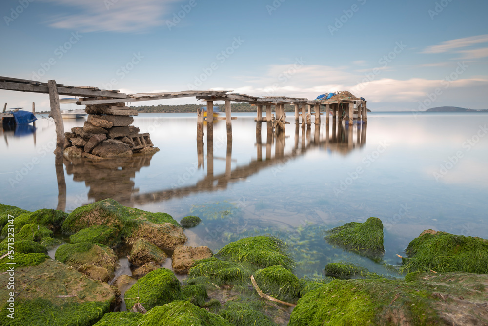 Landscape photography of pier on sea clouds and silky water rocks on shore beautiful weather