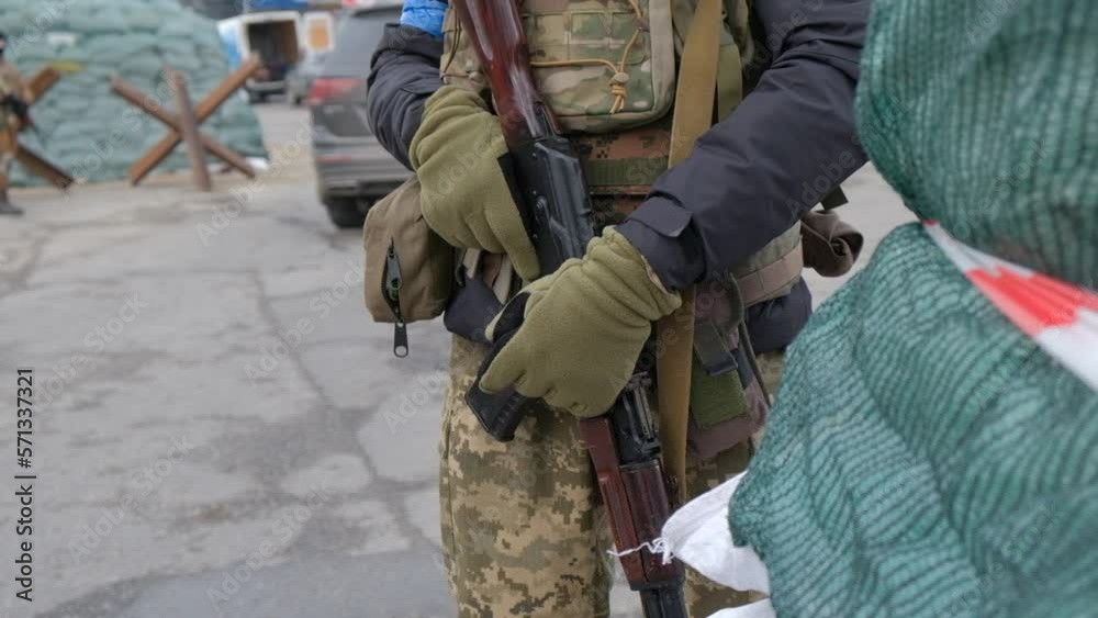 Close up of Ukrainian soldiers at the checkpoint, dressed in military uniforms holding Kalashnikov assault rifles Close up of Ukrainian soldiers at the checkpoint, dressed in military uniforms holding Kalashnikov assault rifles