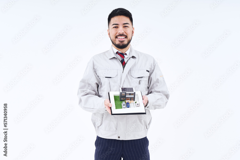住宅模型を持つ作業着姿の男性