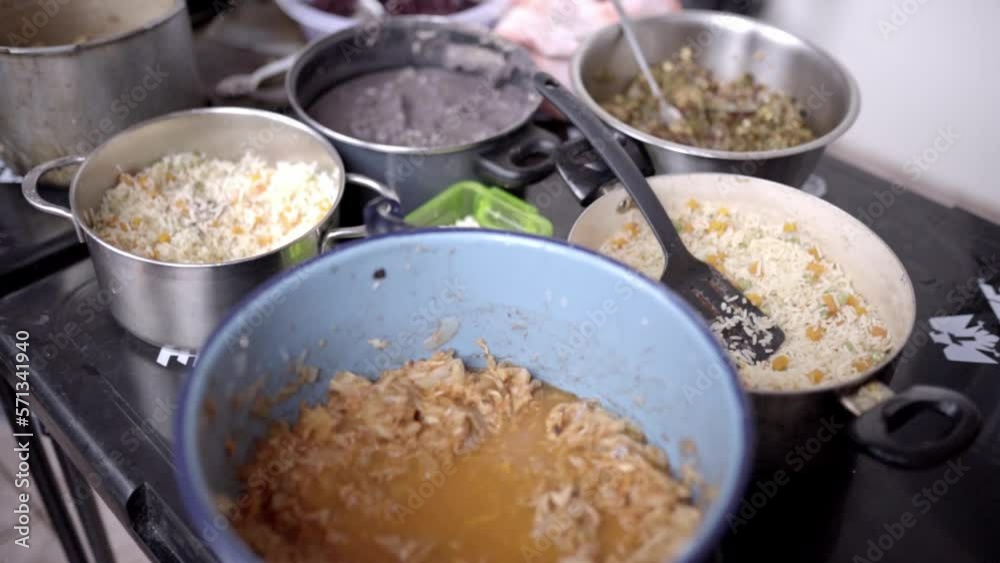 Different pots filled with tinga de pollo, stew, rice, nopal and frijoles Different pots filled with tinga de pollo, stew, rice, nopal and frijoles