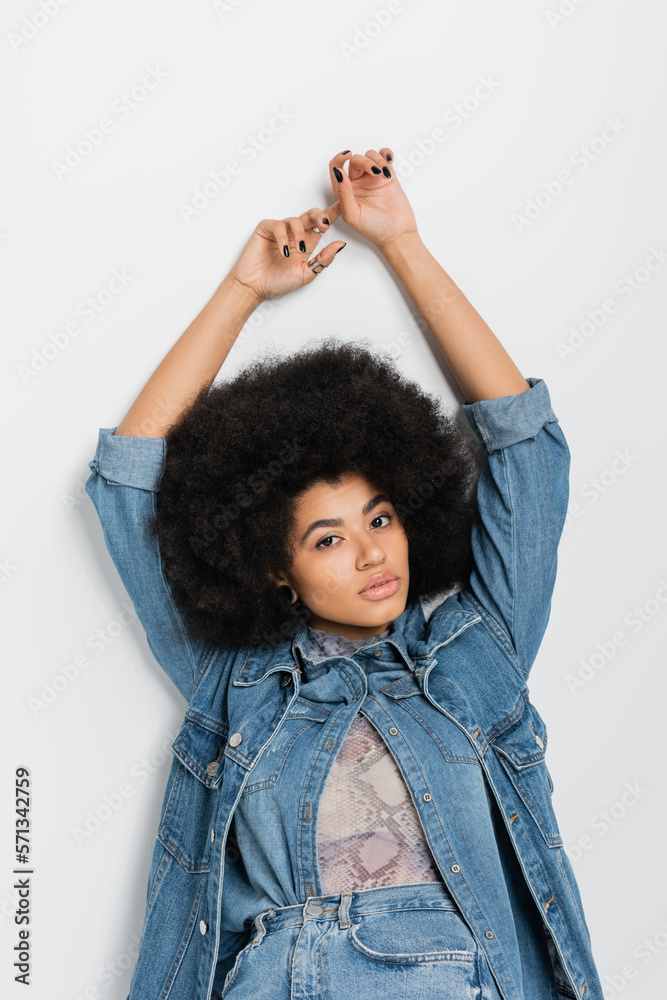 African american woman in denim clothes posing on grey background. African american woman in denim clothes posing on grey background.