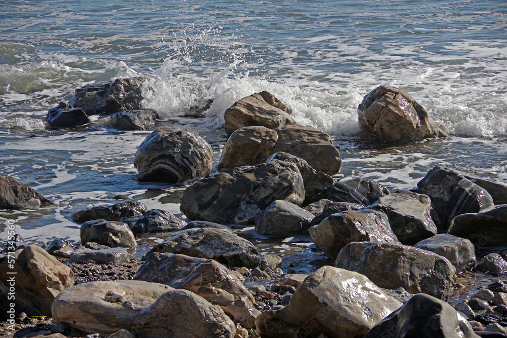Pacific ocean stone and rock water edge in California after heavy winter storms washed the sand beach away Pacific ocean stone and rock water edge in California after heavy winter storms washed the sand beach away