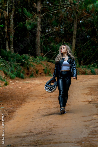 Beautiful blonde woman traveling by motorcycle through old towns walking and walking through its streets and mountains full of gardens enjoying the beautiful views and landscapes on vacation