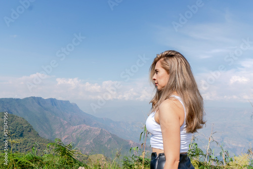Beautiful blonde woman traveling by motorcycle through old towns walking and walking through its streets and mountains full of gardens enjoying the beautiful views and landscapes on vacation