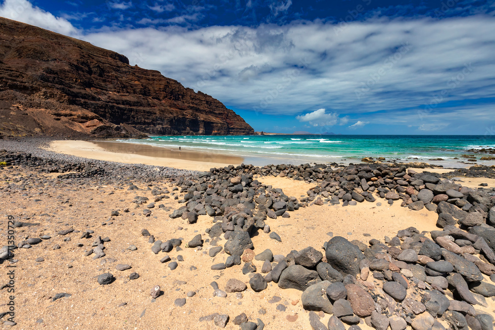 Fototapeta premium Krajobrazy z wysp kanaryjskich z oceanem i niebieskim niebem. Widoki z Lanzarote. Malowniczy pejzaż z oceanem Atlantyckim. Wyspa wulkaniczna. Wulkaniczna sceneria. 