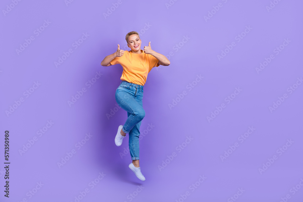 Full size photo of excited energetic girl jump demonstrate thumb up isolated on violet color background