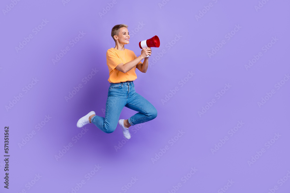 Full body profile photo of excited lady jumping hands hold loudspeaker empty space isolated on violet color background Full body profile photo of excited lady jumping hands hold loudspeaker empty space isolated on violet color background