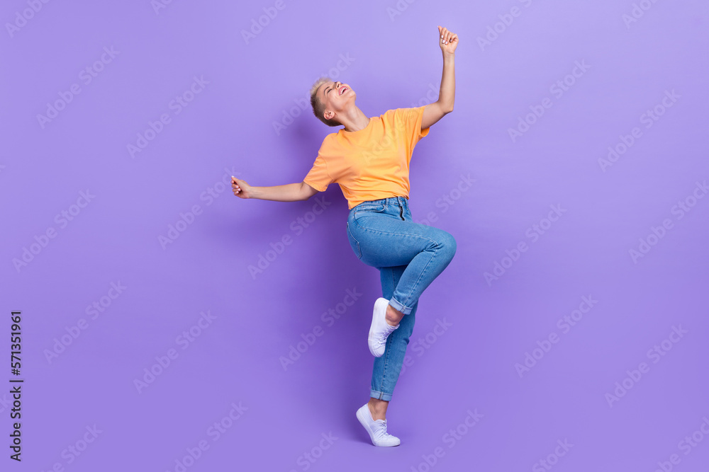 Full size photo of optimistic gorgeous nice girl dressed sneakers denim pants dancing having fun isolated on purple color background