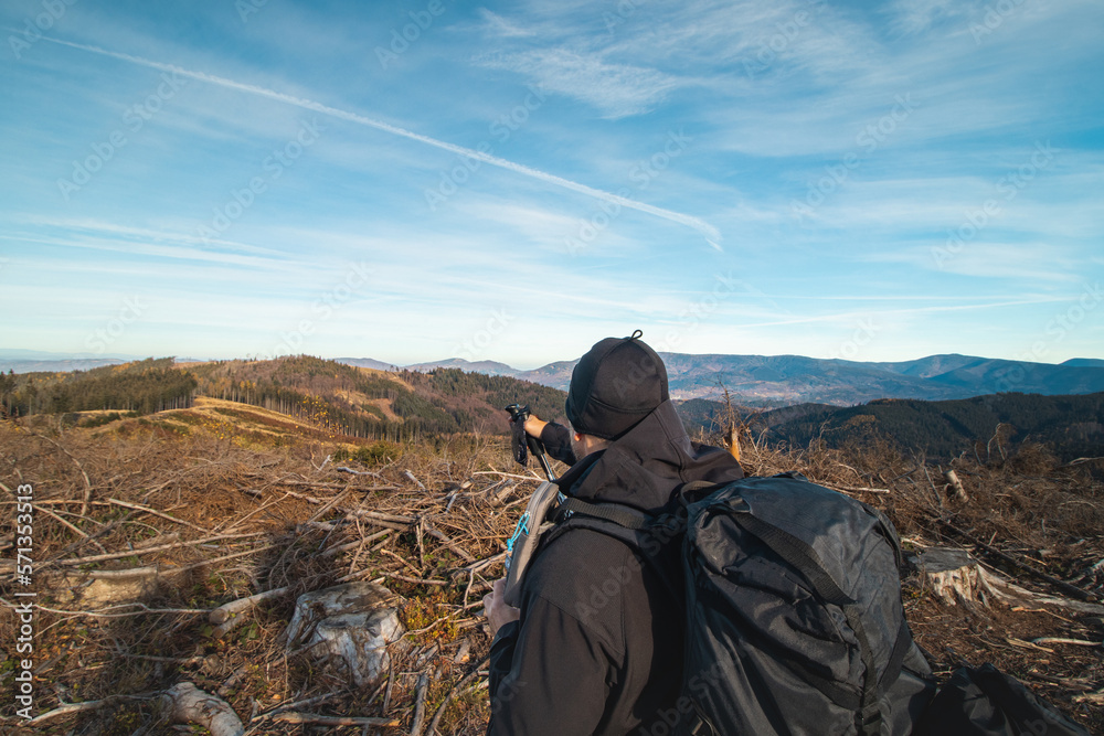 Tourist with a backpack on his back shows a younger inexperienced hiker which way to go and where today's destination is. From travellers' lives Tourist with a backpack on his back shows a younger inexperienced hiker which way to go and where today's destination is. From travellers' lives