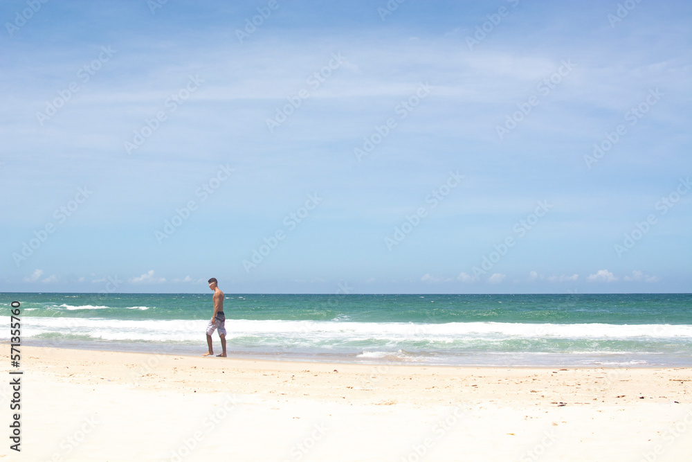 FLORIANOPOLIS, BRAZIL - JANUARY 22, 2023 : a man walks on the beach Barra da lagoa, Florianopolis, Brazil