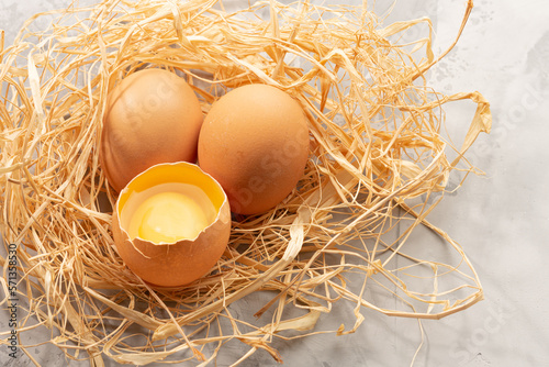 Brown eggs lay in brown paper that is made like a bird's nest. White background. High quality photo