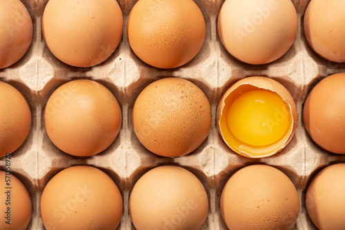 Cracked and whole chicken eggs in carton pack, top view. High quality photo