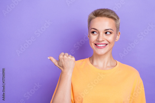 Photo portrait of cheerful positive good mood lady wear trendy style t-shirt look point finger mockup present isolated on violet color background