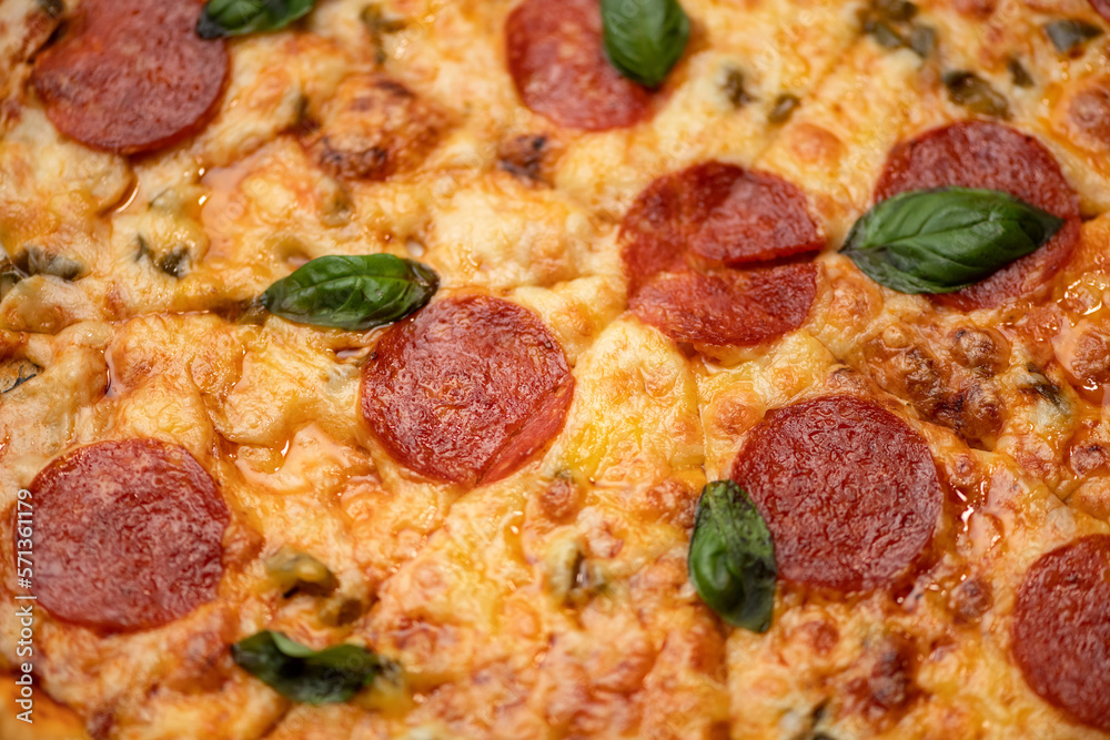Fragment of pizza pepperoni. Pizza with cheese, pepperoni and basil. Italian cuisine. Fast food. Close-up. Top view. Soft focus. Fragment of pizza pepperoni. Pizza with cheese, pepperoni and basil. Italian cuisine. Fast food. Close-up. Top view. Soft focus.