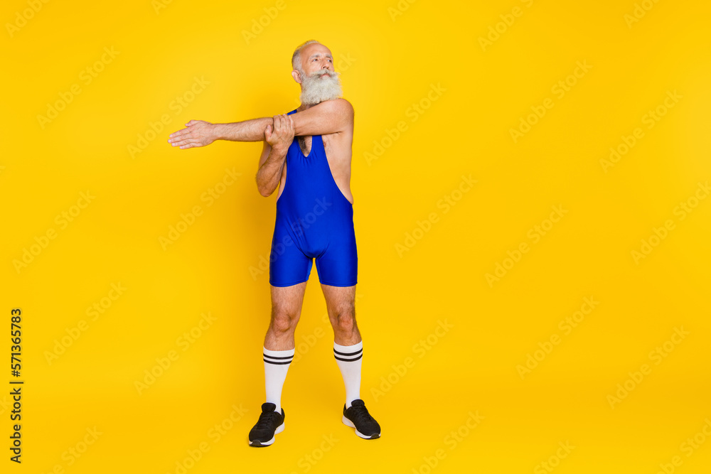 Full length photo of energetic motivated fitness coach bodybuilder do activity effort look empty space isolated on yellow color background Full length photo of energetic motivated fitness coach bodybuilder do activity effort look empty space isolated on yellow color background