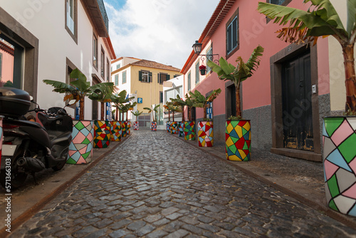 Vintage street with colorful houses, bike and banana trees in a fishing town on Madeira island