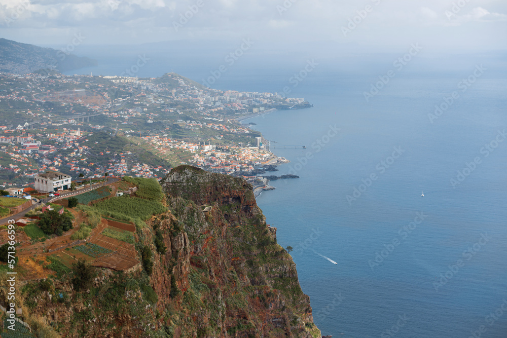 Amazing panoramic view of madeira island with mountains, city, houses, agro, ocean and boat. View from the observation deck Cabo Girão Skywalk