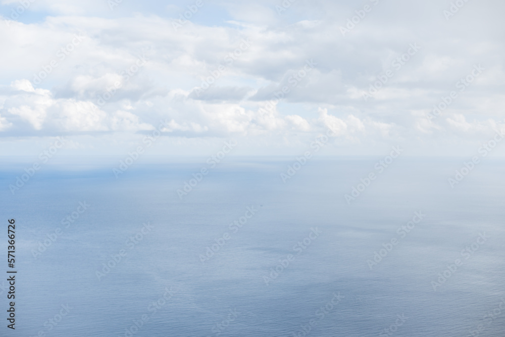 Amazing blue Atlantic ocean with white clouds. Beautiful skyline