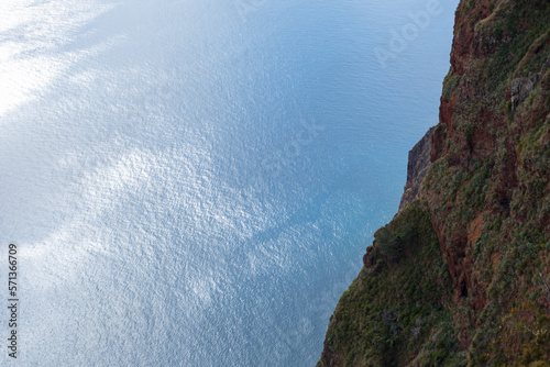 Blue ocean and cliff rock mountion on the island of Madeira from above photo