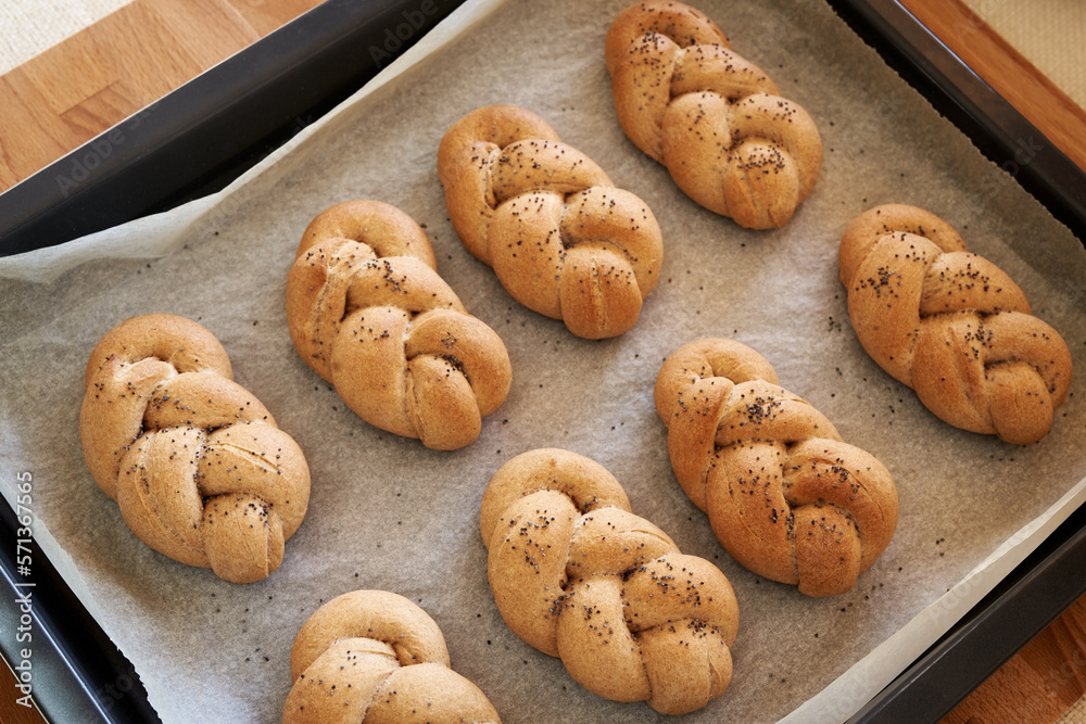 Homemade braided bread rolls made from whole grain spelt flour on a baking sheet Homemade braided bread rolls made from whole grain spelt flour on a baking sheet
