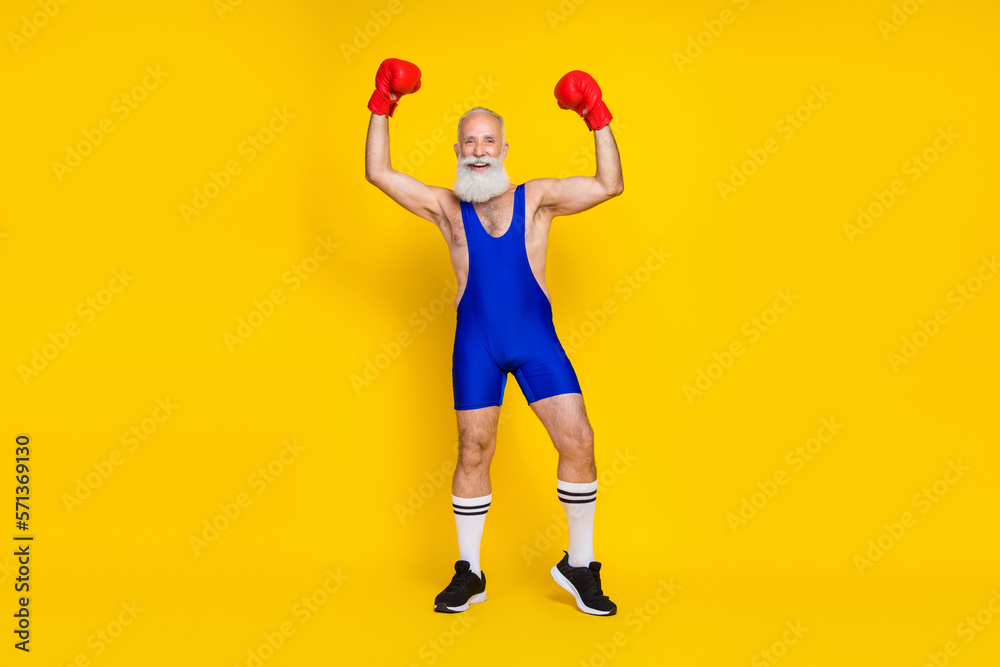 Full length portrait of delighted person raise fists hands wear boxing gloves achieve isolated on yellow color background