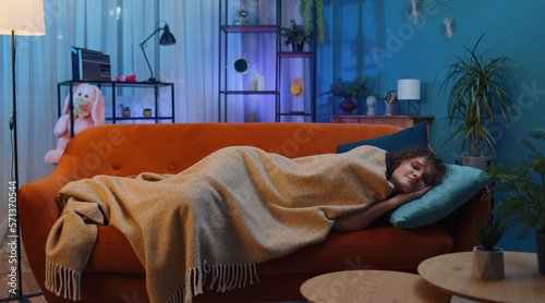 Fotografie Tired young woman with curly lush hairstyle lying down in bed taking a rest at home room