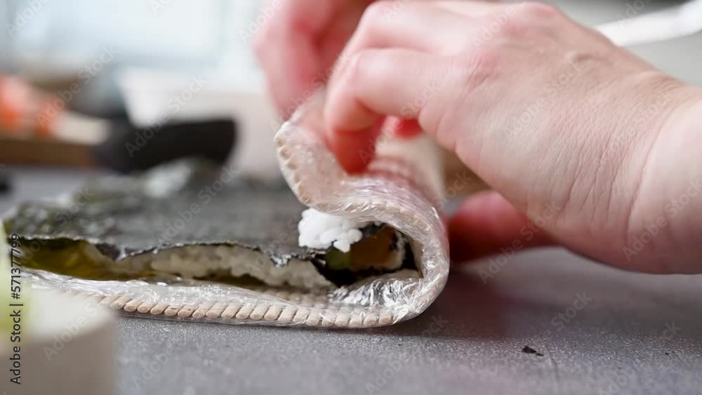 Rolling sushi, cooking process. Rice, fish fillets, cream cheese, avocado and cucumbers. Rolling sushi, cooking process. Rice, fish fillets, cream cheese, avocado and cucumbers.