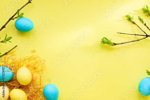 Easter spring holiday flatlay with nest, yellow eggs and blue eggs on yellow background. Easter concept. top view. copy space. flat lay