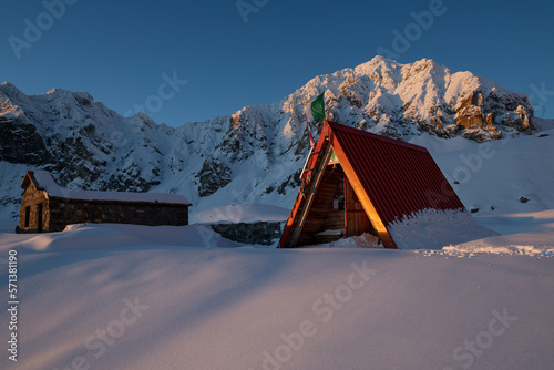 Alba invernale al bivacco danilo sartore (valle maira) appena imbiancato da una nevicata invernale photo