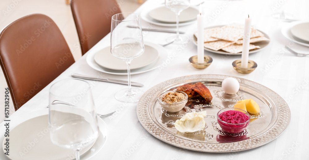 Passover Seder plate with traditional food on served table in dining room