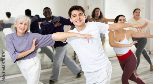 Group of dancing people practicing energetic swing during a class in a dance studio