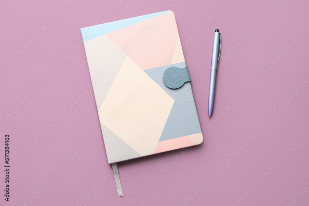 Notebook and pen on lilac background Notebook and pen on lilac background