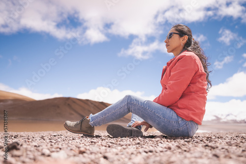 mujer latina contemplando laguna entre montañas nevadas de los Andes