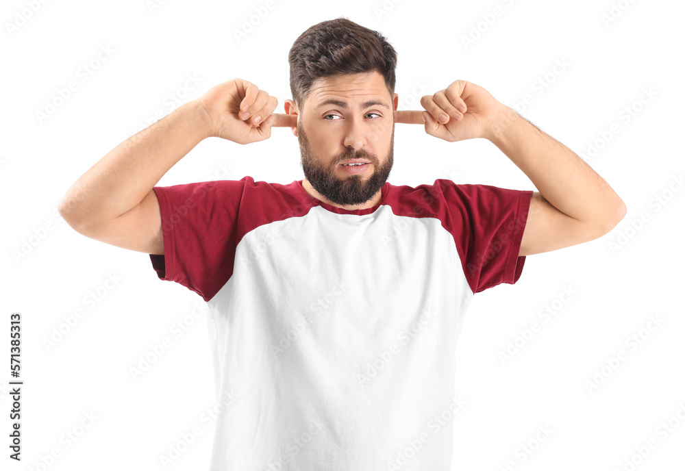Irritated young man suffering from loud noise on white background Irritated young man suffering from loud noise on white background