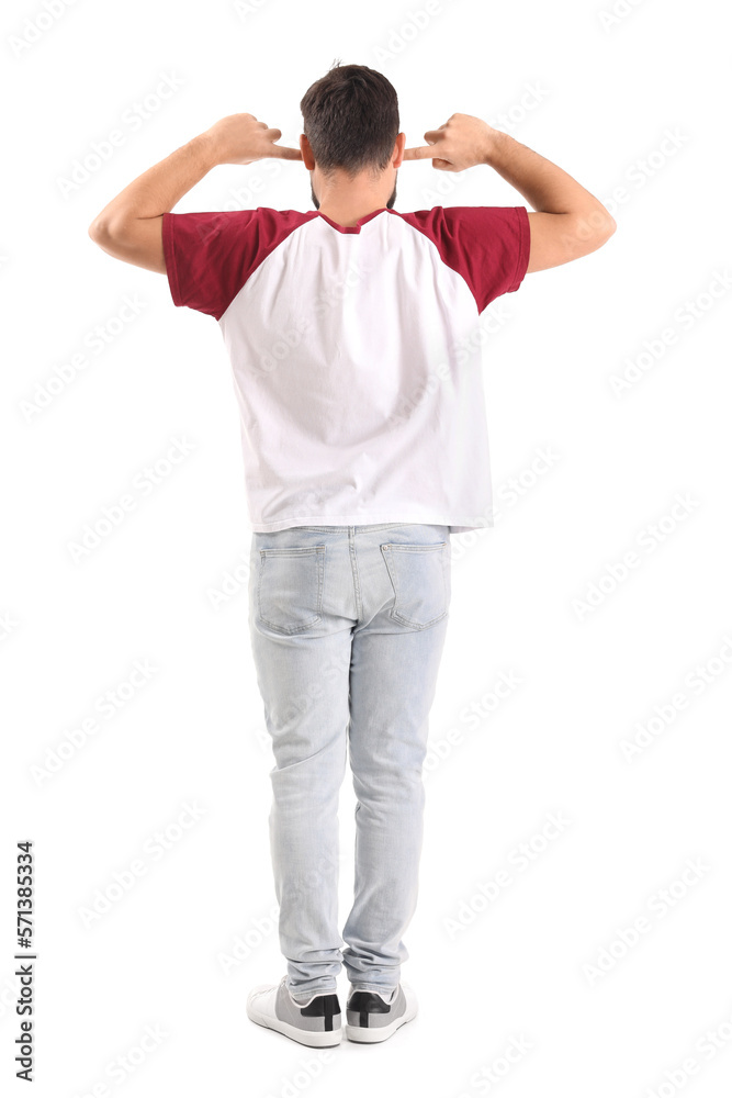 Young man suffering from loud noise on white background, back view Young man suffering from loud noise on white background, back view