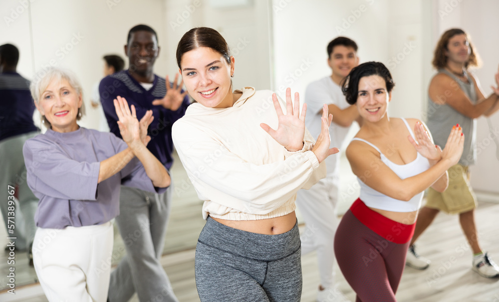 Fototapeta premium Group of positive people practicing energetic lindy hop movements at a dance school in a lesson
