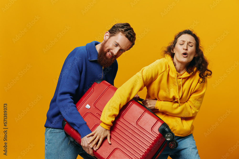 Obraz premium Woman and man smiling, suitcases in hand with yellow and red suitcase smiling merrily and crooked, yellow background, going on a trip, family vacation trip, newlyweds.